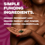 Person holding two green capsules with text about simple ingredients on a pink background